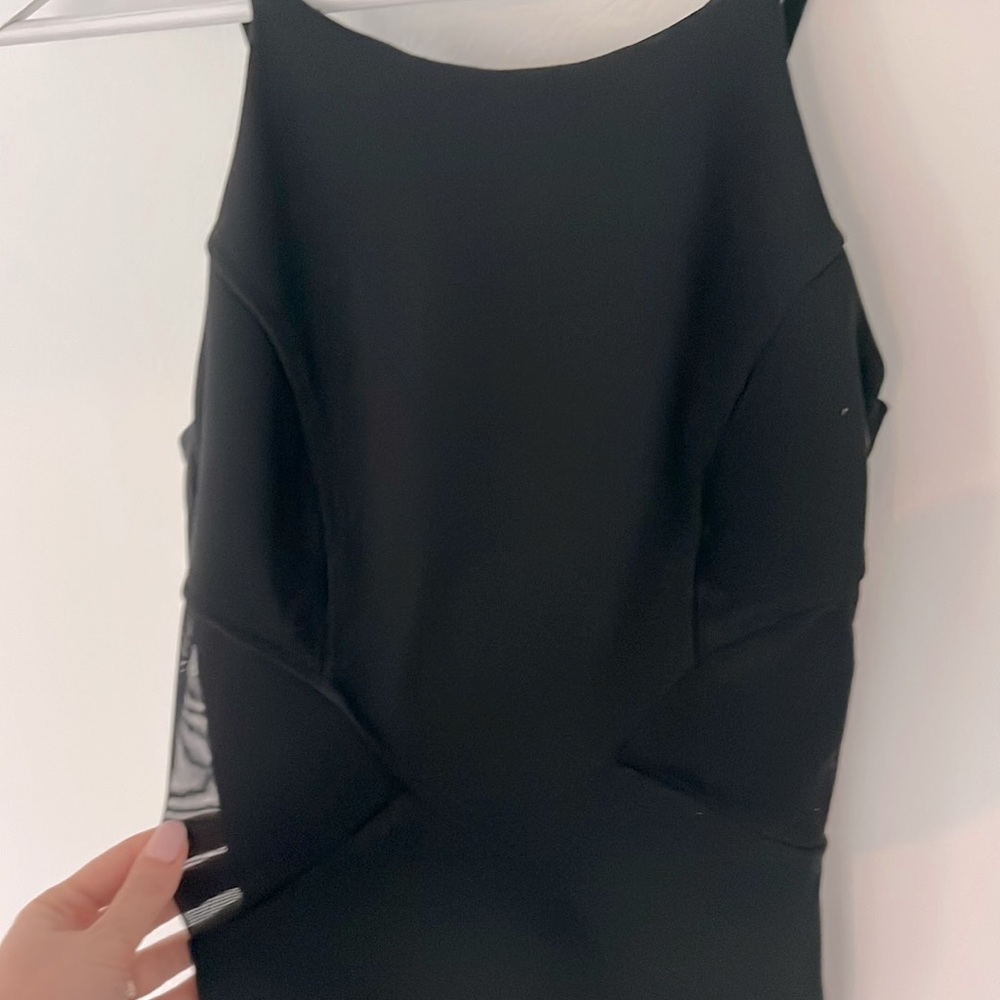 Black cocktail dress with see through mesh inserts.
